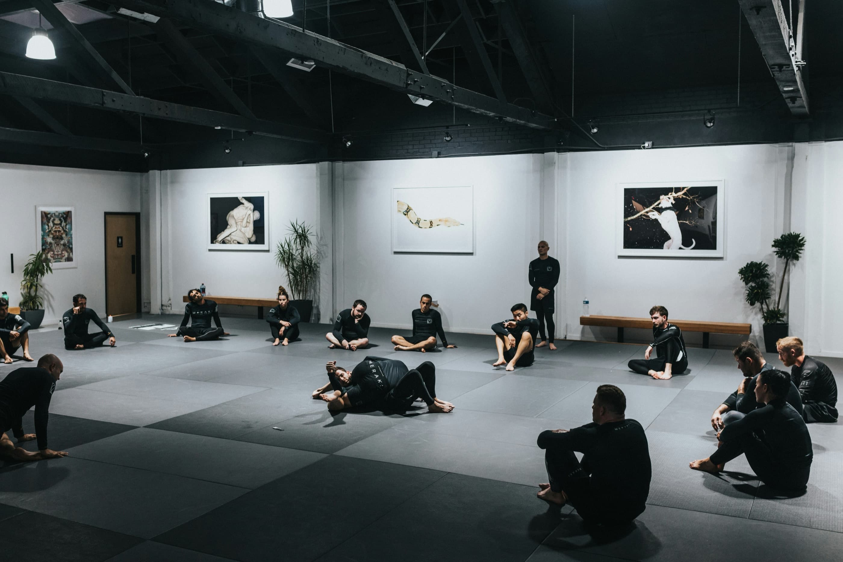 Gruppe auf der Matte einer dunklen Trainingshalle